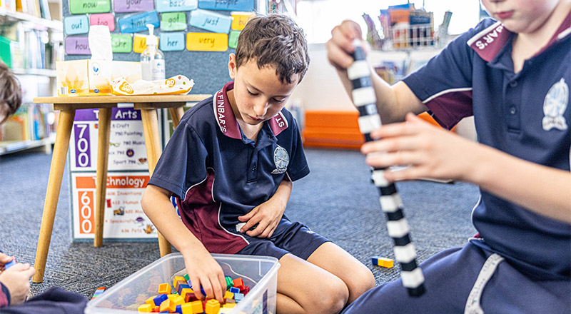 Student at St Finbar’s Catholic Primary Glenbrook using counting blocks on the floor with class mates